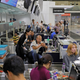 Stranded travelers sit in the check-in counters at Hong Kong International Airport, Aug. 12, 2019.